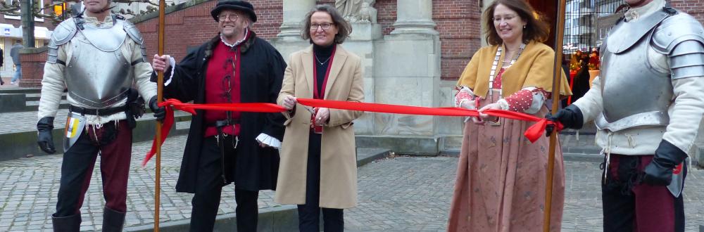 Ministerin Ina Scharrenbach (3. von links) und Bürgermeisterin Ulrike Westkamp durchtrennten gemeinsam mit Ludwig Maritzen (2. von links) von der Hanse-Gilde Wesel das symbolische rote Band vor dem Berliner Tor. Gespannt wurde das Band zwischen den Hellebarden der mittelalterlichen "Wachen" (hier gespielt von zwei Mitgliedern der Hanse-Gilde).