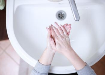 Hände werden am Waschbecken gewaschen