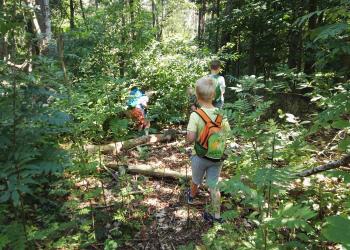 Kind mit Rucksack im Wald