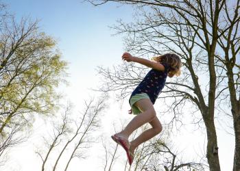 Kind springt auf einem Trampolin