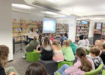 Das Foto zeigt eine Schulklasse bei einer Lesung.