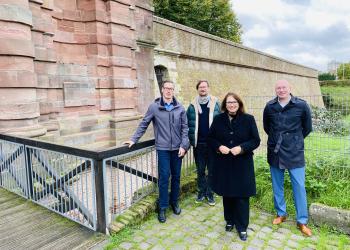 Bürgermeisterin Ulrike Westkamp, Beigeordneter Dr. Markus Postulka (rechts), Fachbereichsleiter Thorsten Hummel (links) sowie Tim Winter vom Gebäudeservice der Stadt Wesel freuen sich über den sanierten Bauabschnitt der Wallmauer.