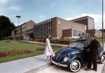Ansicht des Bühnenhaus aus den 60er Jahren. Konzertbsucher steigen aus einem VW-Käfer aus