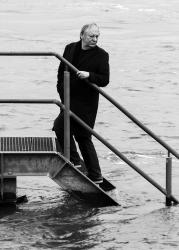 Wilfried Schmickler steht auf einer Treppe im Fluss