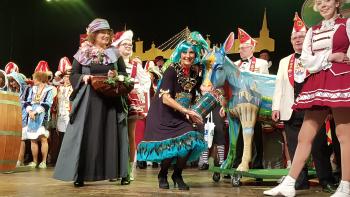 Ulrike Lubek verkleidet auf der Bühne bei der Eselordenverleihung Verkleidete Karnevalisten mit bunter Eselsfigur