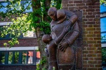 Mauer mit drei Figuren aus Metall