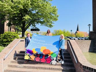 Sozialdezernent Rainer Benien, Bürgermeisterin Ulrike Westkamp und die Integrationsbeauftragte der Stadt Wesel, Claudia Wenzel, präsentieren im Rathaus-Innenhof einen Banner zum Inklusiven Handlungskonzept der Stadt Wesel