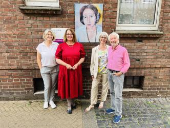 von link: Gleichstellungsbeauftragte Regina Lenneps, Bürgermeisterin Ulrike Westkamp und die Eheleute Suhrborg vor dem Portrait der Malerin Erna Suhrborg in der Sandstraße