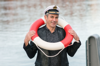Das Foto zeigt einen Mann mit einem Rettungsring um den Hals.